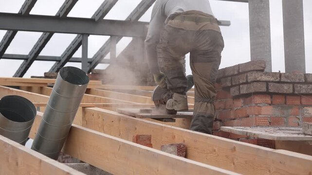 Professional builder using a diamond blade power tool for brick cutting