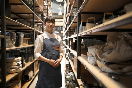Small business owner in a workshop or storage area, looking at the camera