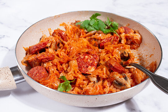 Bigos, Polish dish bigos, on a marble table, stewed meat with cabbage, chorizo sausages, mushrooms, homemade, without people,