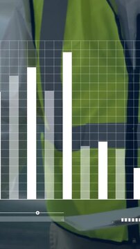 Vertical video: Site lead leaning over table checking tablet as dashboard bars moving job status