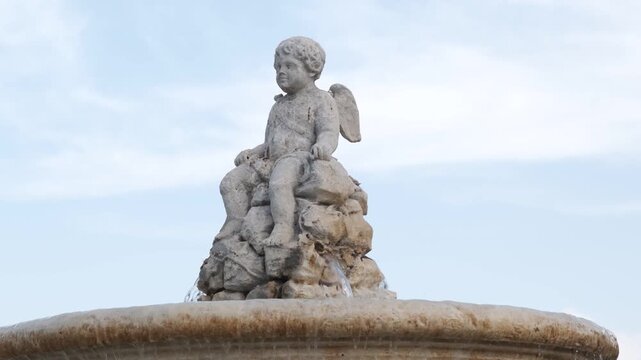 Cherub statue on fountain under clear sky