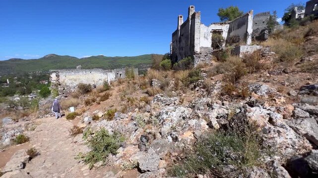 Ancient hillside ruins with narrow path leading down from stone chapels to the valley in Kayak&ouml;y, Turkey