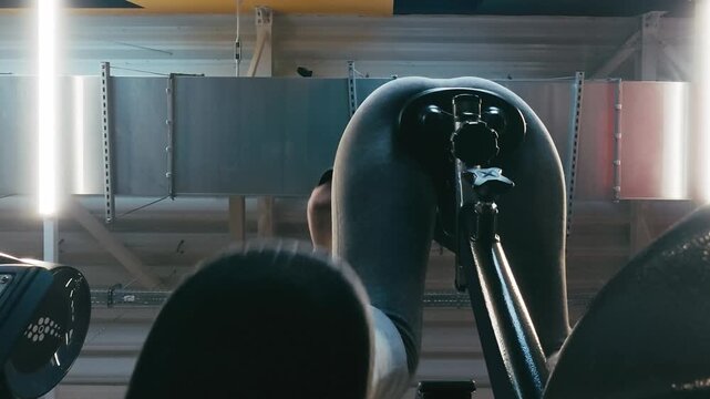 Viewed From Below, A Woman Trains On An Elliptical Machine In The Gym