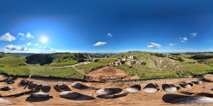 360 aerial photo taken with drone of huts in a circle that reflect Eswatini traditional housing on sunny afternoon at Sibebe Resort Cultural Village outside of Mbabane, Eswatini