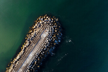 Obraz premium Aerial top down view of a concrete breakwater in the ocean The Concept of Coastal Engineering