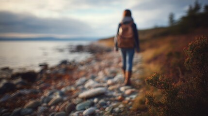 Fototapeta premium person walking along coastline with blured nature background