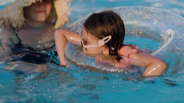 mom and daughter in pool have fun during summer vacation. Child having fun in swimming pool. 