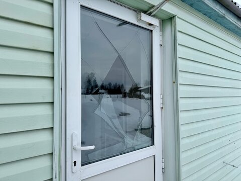 Broken glass door of a private house in winter, signs of vandalism or burglary, damaged window in residential building