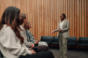 Confident black woman delivering a presentation to attentive seminar attendees. Business...