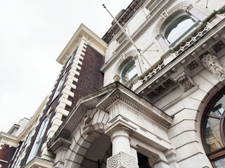 Fototapeta premium Historic neoclassical building facade with ornate stone columns and carved details in London, UK