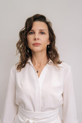 Fototapeta premium Professional female cosmetologist looking at camera, portraying expertise, confidence, and experience in beauty, medical aesthetics, and skin care services. Concept of beauty treatment.