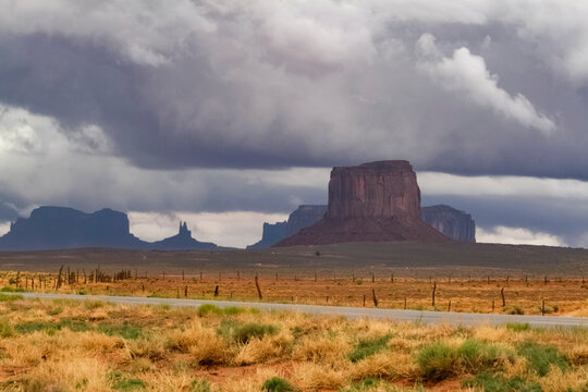 Monument Valley butte under heavy storm clouds in desert landscape