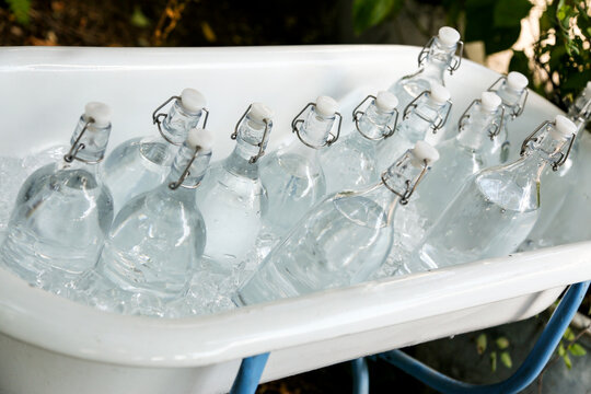 Glass bottles chilling in ice bucket outdoor refreshment scene