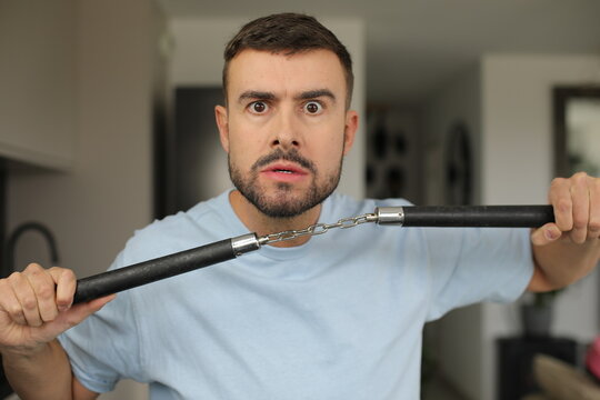 Man holding a black nunchaku