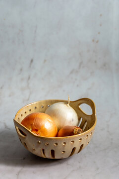 Yellow and white onion in ceramic basket 