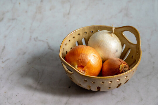 Yellow and white onion in ceramic basket 