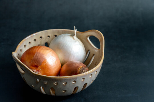 Yellow and white onion in ceramic basket 