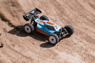 Radio-controlled car speeding on dirt track, raising dust © Zoran Jesic