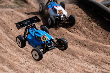 Radio-controlled cars jumping on dirt track during race © Zoran Jesic