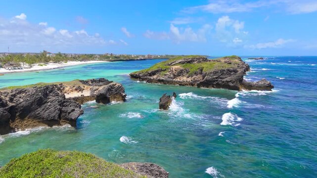 Aerial view of rocky islets surrounded by turquoise ocean water and white sand beach along the coastline of Watamu Beach, Kenya.