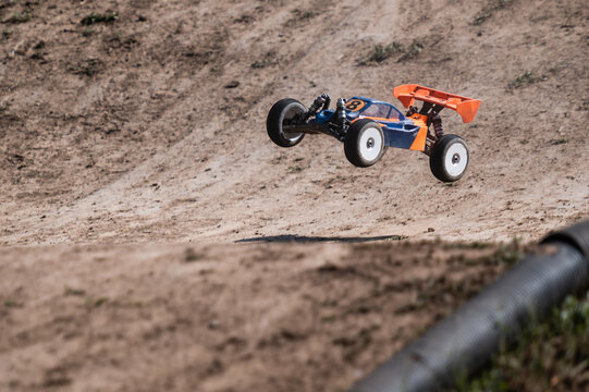 Radio-controlled car jumping on a dirt track during a race