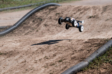 Radio-controlled car jumping on dirt track © Zoran Jesic