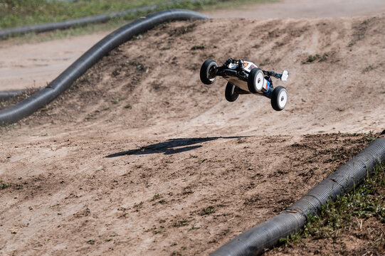 Radio-controlled car jumping on dirt track