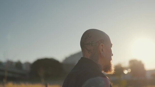 Tattooed man running in a park during sunset