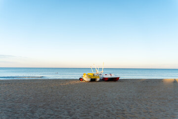 Obraz premium Two catamarans for water excursions are moored on the sandy shore of the sea, lake or ocean.
