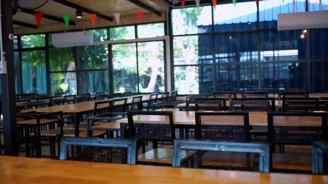 Tracking Shot Over Empty Wooden Dining Tables in a Sunlit Restaurant.