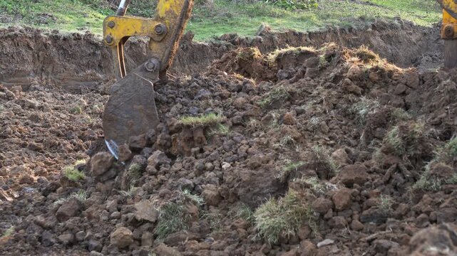 Excavator Digging Soil at Indian Construction Site. Indian Excavator Machine Working on Soil Land Development Project. Indian Village Infrastructure Development.