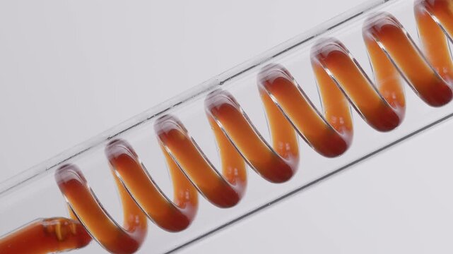 Concept craft drink coffee industry. Series of glass coil turns filled with amber liquid in tube.