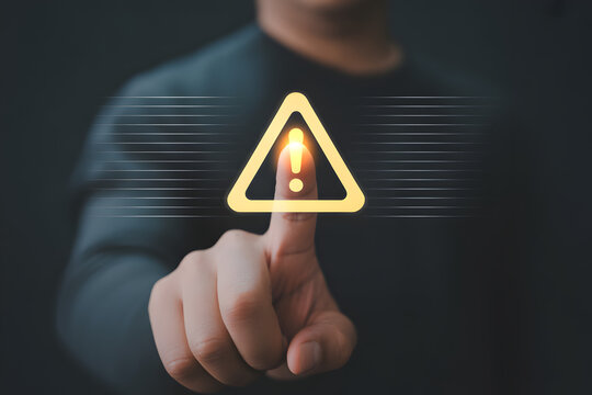 Human Finger Touching Digital Warning Sign with Triangle Exclamation Mark Icon, Alert System Notification for Cyber Security Threat, Emergency Error and Risk Management in Modern Digital Environment