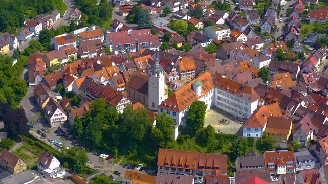 An panoramic aerial view around the old town in the city Waldenbuch on a sunny summer noon in Germany .