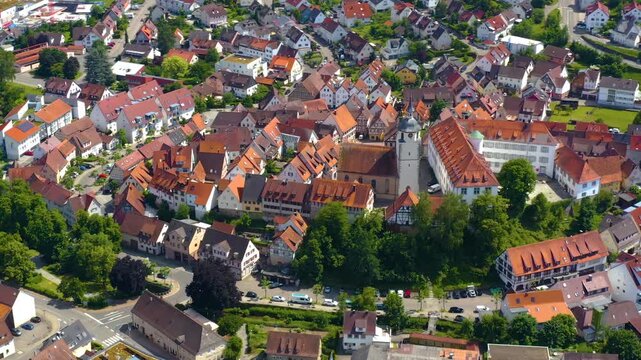 An panoramic aerial view around the old town in the city Waldenbuch on a sunny summer noon in Germany .