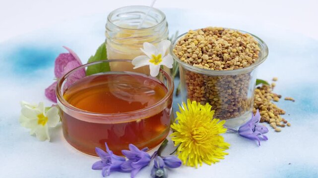 Honeycomb, bee pollen and honey jar arranged on a rotating background