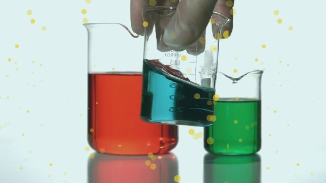 Animation of spots over hand holding beaker