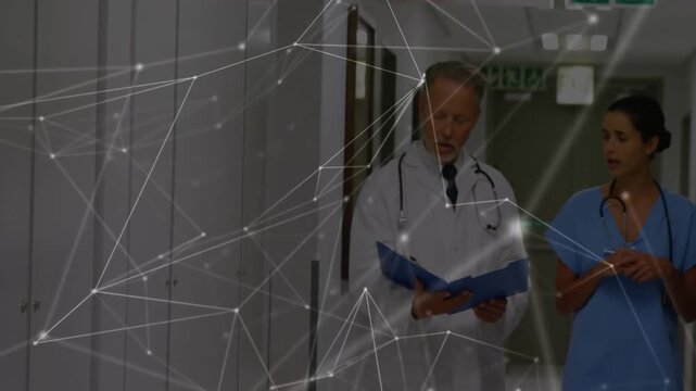 Entering hospital corridor, doctor reviewing records with nurse while network overlay showing data