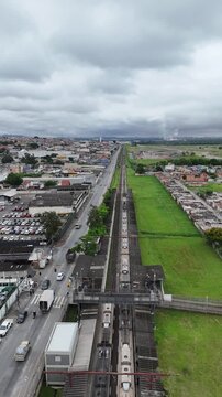Imagem a&eacute;rea do bairro Br&aacute;s Cubas mostra linha ferrovi&aacute;ria, avenida urbana e expans&atilde;o residencial em Mogi das Cruzes