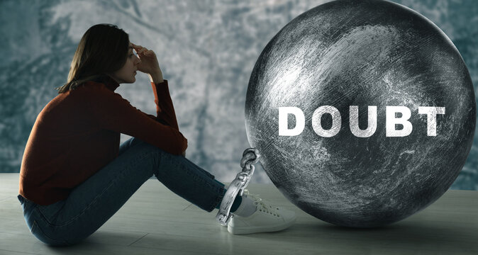 Doubt. Sad woman chained to huge weight on floor. Lack of confidence making life harder