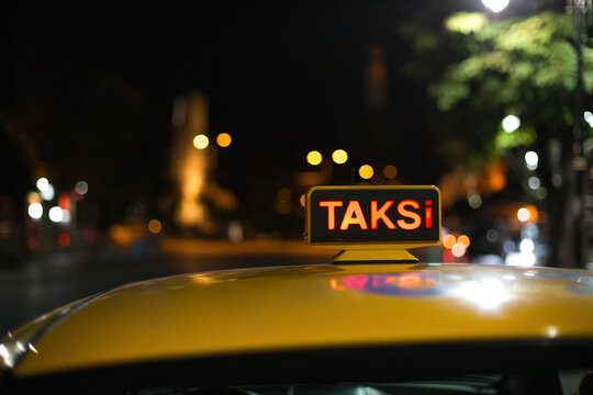 Yellow Taxi Sign Reading TAKSİ On Car Roof In City Night With Bokeh Lights from Street lights
