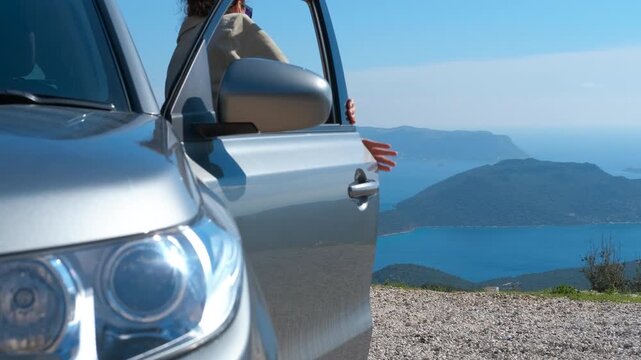 Romantic couple enjoying the scenic view on a road trip. Mature couple getting out of their car at a stunning viewpoint, walking to the cliff edge, and affectionately hugging while admiring the sea