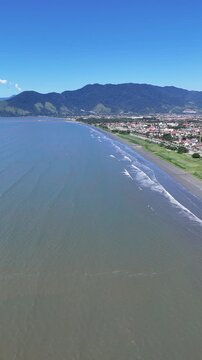Vista a&eacute;rea da Praia do Porto Novo em Caraguatatuba com mar calmo, faixa de areia e paisagem do litoral norte paulista