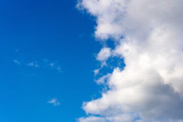 Obraz premium Blauer Himmel mit weißen Wolken auf der rechten Bildseite und viel freiem Raum