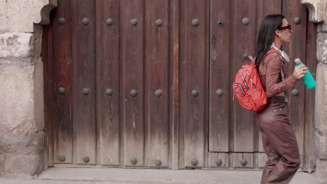 Happy university student dancing while walking on the street. door, Background,