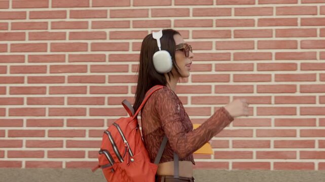 Happy young woman dancing while walking down the street