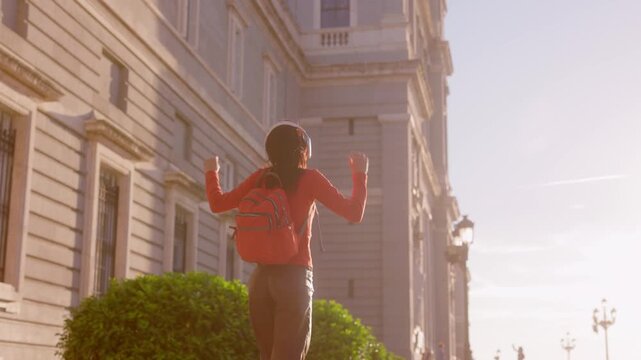 Happy woman with headphones dancing in Madrid Almudena Cathedral