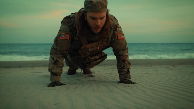 American soldier doing push-ups on the beach for training near the ocean