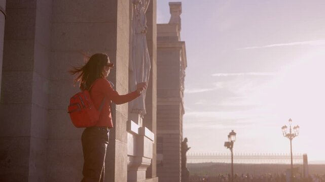 Happy female traveler dancing at sunset in Madrid Almudena Cathedral, spain