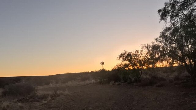 Time-lapse of the start of a sunset in the Karoo with a windpump silhouetted on the horizon. 4K video.